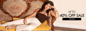 Woman sitting on a decorative chair with a sale banner in the background